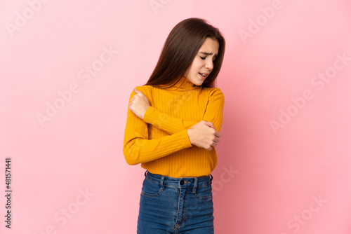 Little girl isolated on pink background with pain in elbow