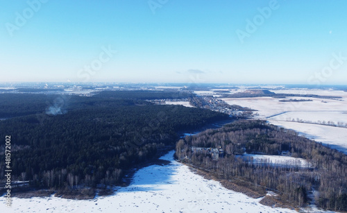 View from a height of a large winter landscape with a snowy field of the suburbs