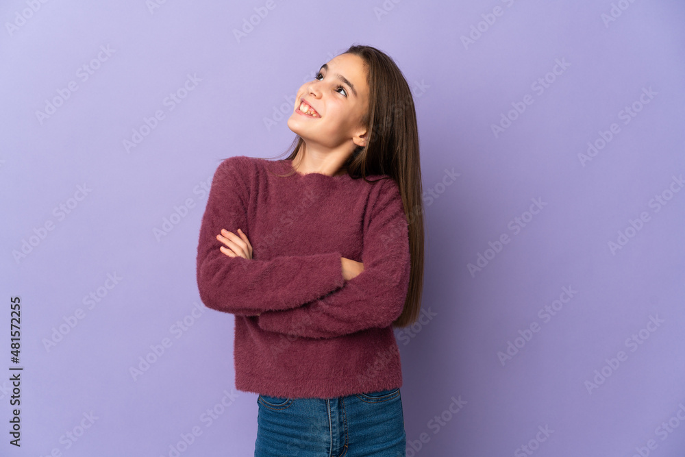 Little girl isolated on purple background looking up while smiling Little girl isolated on purple background looking up while smiling
