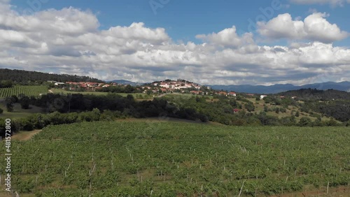 drone flies low above vineyards towards romantic old town Stanjel in Slovenia photo