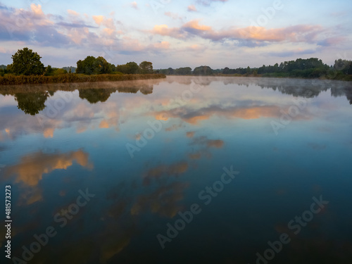Morning sky with clouds over the river. Beautiful sunrise and reflecting clouds in a river. Nature landscape  reflection  blue and pink color sky  landscape during dawn