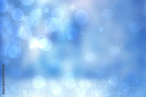 Abstract blurred festive winter christmas or Happy New Year background with shiny blue and white bokeh lighted snow landscape with sky and sun. Space.