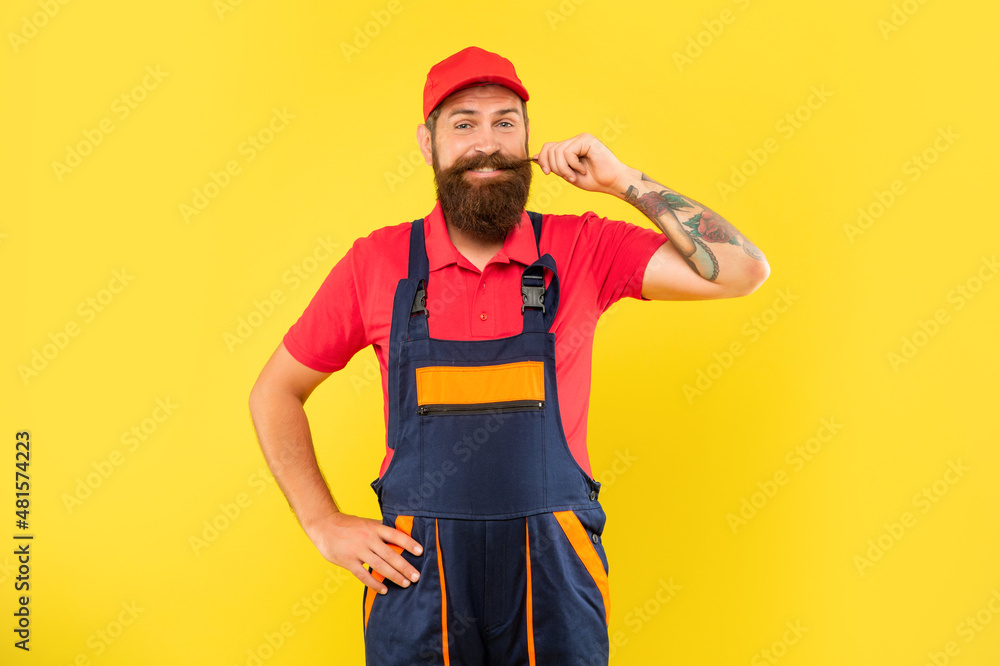 cheerful bearded deliveryman in work clothes on yellow background cheerful bearded deliveryman in work clothes on yellow background