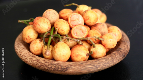 Menteng fruit or Baccaurea racemosa on wood plate.  photo