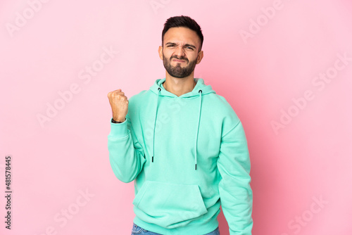 Young caucasian man isolated on pink background with unhappy expression © luismolinero