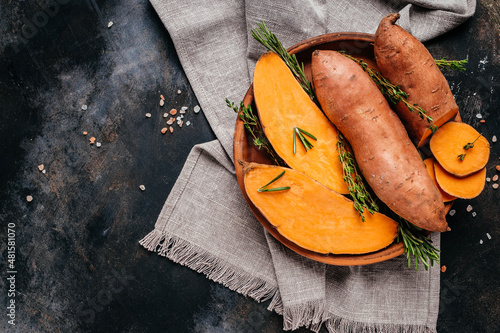 Organic orange sweet potato. Raw sweet potatoes or batatas. vegan food ingredient. banner, menu, recipe place for text, top view photo
