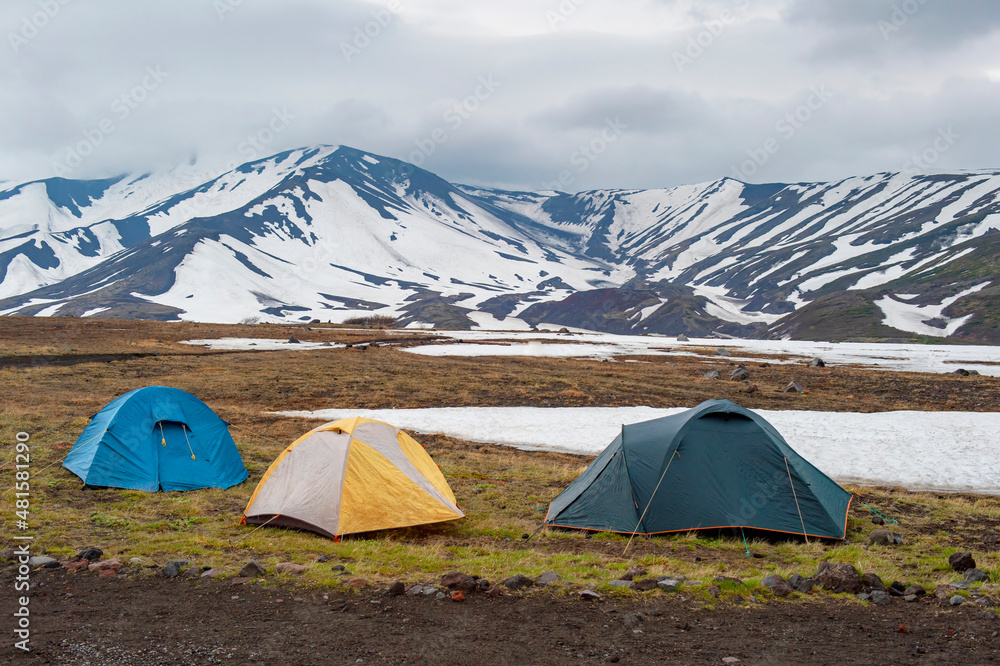 Tent camp in the mountains against the backdrop of volcanoes. Kamchatka, Russia