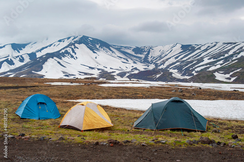 Tent camp in the mountains against the backdrop of volcanoes. Kamchatka, Russia