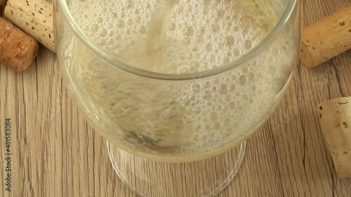 Wine is poured into a glass on the background of wine corks. photo