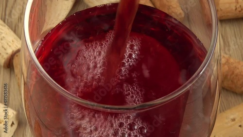 Wine is poured into a glass on the background of wine corks. photo