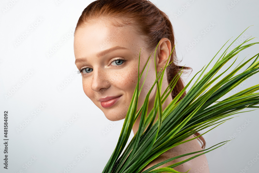 Naklejka premium Pretty Young Lady Holding Green Plant Standing Over Gray Background