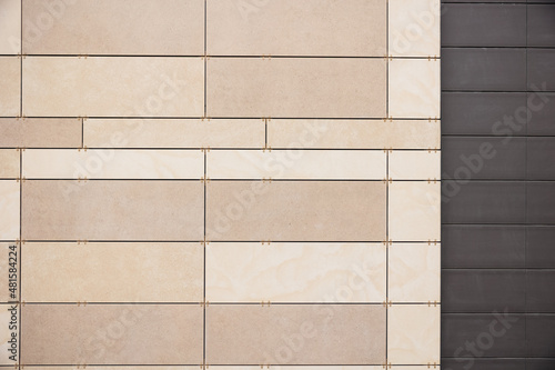 Modern ventilated facade tiles in beige and brown colors on the wall. photo