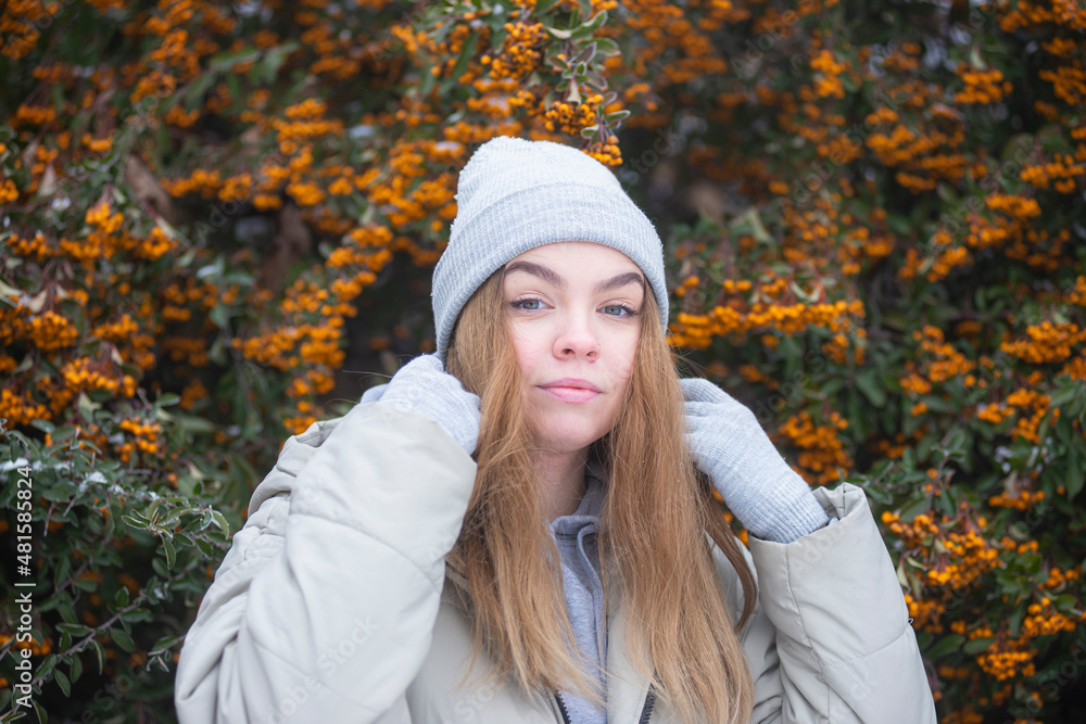 portrait of a woman against the background of frozen branches of yellow rowan, blonde against the background of snowy yellow berries, Beautiful young woman portrait of a woman against the background of frozen branches of yellow rowan, blonde against the background of snowy yellow berries, Beautiful young woman