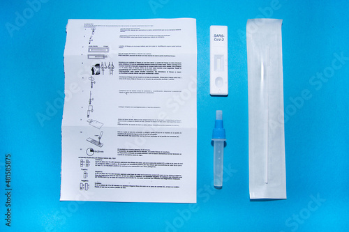 Information still life on what is contained in an antigen test. Instructions for use, tube with diluent, swab, test to introduce the diluent drops and mucosa. photo