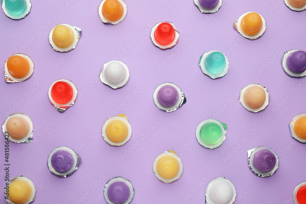 Tasty bright jelly cups on violet background, flat lay