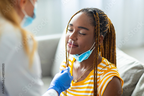 Black woman getting nasal coronavirus swab test at home