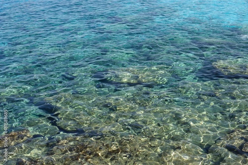Blue sea background. close up water, ripples texture. Bubbly rocks underwater in the shallows. Cyprus. 