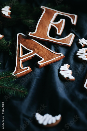 Weihnachten backen. Ein dunkles Flatlay mit Buchstaben Geschenke aus Lebkuchen mit Zuckerguss