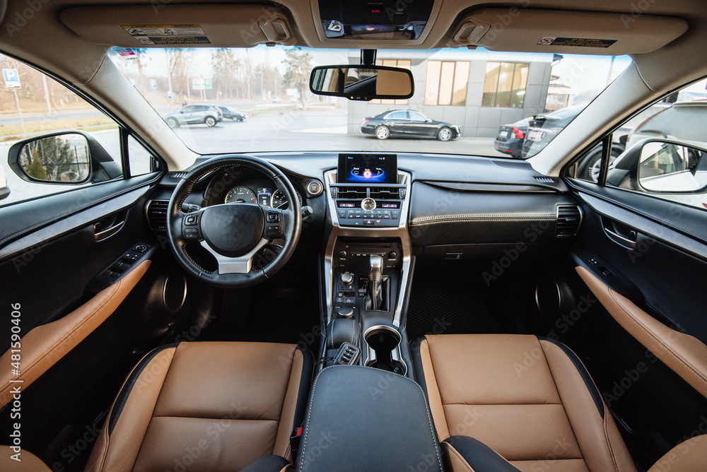 Modern luxury car Interior - steering wheel, shift lever and dashboard. Car interior luxury inside. Steering wheel, dashboard, speedometer, display.Yellow leather interior.