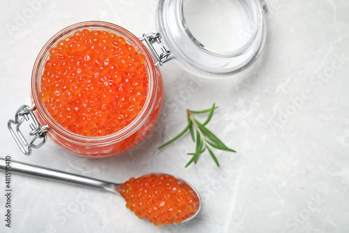 Delicious red caviar and rosemary on light grey table, flat lay. Space for text