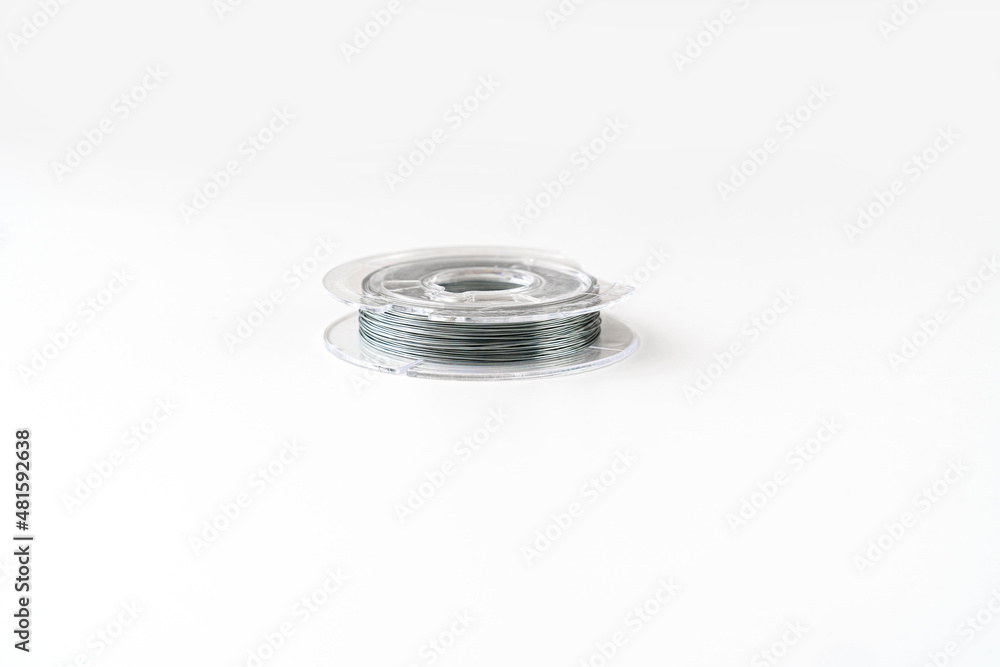 wire coil for weaving and needlework from beads on a white background. accessories for creating costume jewelry. sale of goods for creativity and needlework. wire coil for weaving and needlework from beads on a white background. accessories for creating costume jewelry. sale of goods for creativity and needlework.