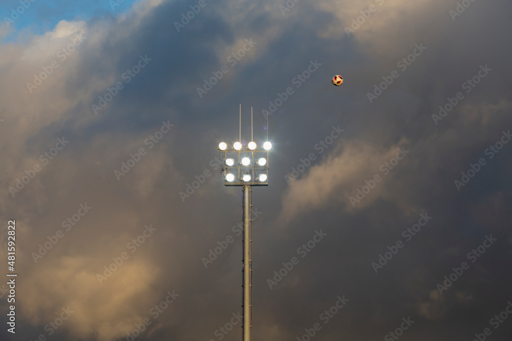 Lighting of a soccer field with storm clouds in the background