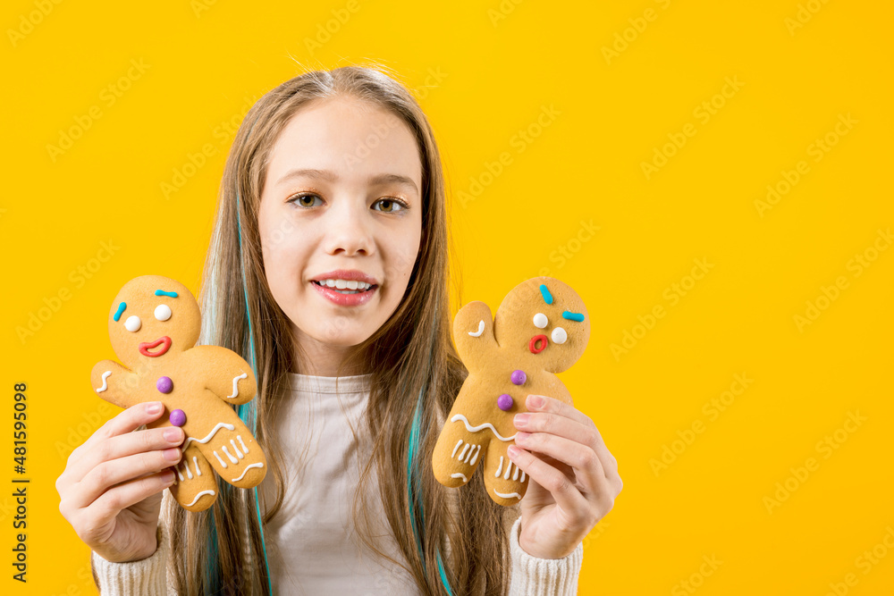 A cute girl holds in her hands two cookies in the form of a man. Funny teenager. Schoolboy A cute girl holds in her hands two cookies in the form of a man. Funny teenager. Schoolboy