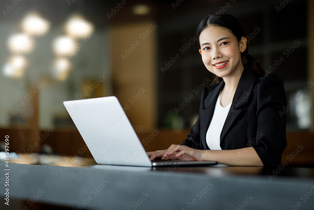 Shot of an Asian young business woman working on a laptop computer in her workstation.Portrait of Business people employee freelance online marketing e-commerce telemarketing concept. Shot of an Asian young business woman working on a laptop computer in her workstation.Portrait of Business people employee freelance online marketing e-commerce telemarketing concept.