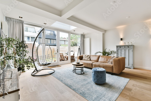 A lovely living room with a brown sofa and white ones with hanging swings photo