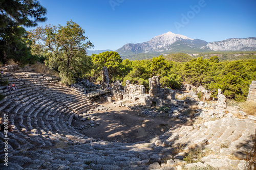 Ruins of the aqueduct of the ancient ancient city of Phaselis illuminated by the bright sun in Pine forest, woods in sunny weather in Turkey, Antalya, Kemer. Turkey national nature landmarks. photo