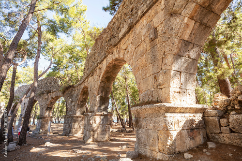 Ruins of the aqueduct of the ancient ancient city of Phaselis illuminated by the bright sun in Pine forest  woods in sunny weather in Turkey  Antalya  Kemer. Turkey national nature landmarks.