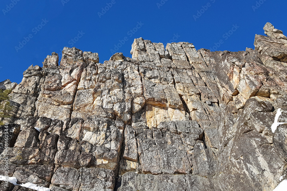 a rocky massif in the foreground and a blue sky