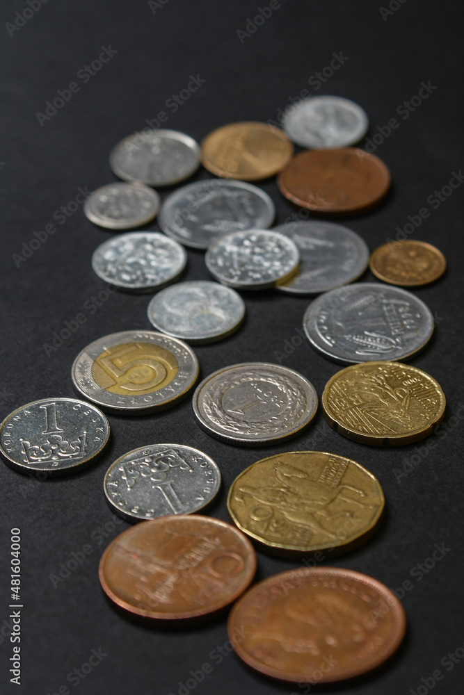 Coins of different countries. A scattering of coins on a black background. Shallow depth of field Coins of different countries. A scattering of coins on a black background. Shallow depth of field