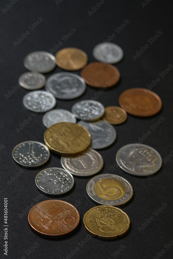 Coins of different countries. A scattering of coins on a black background. Shallow depth of field
