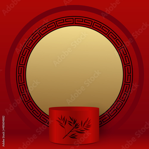 Vitrine rouge,or et noir, d’ambiance chinoise avec au premier plan 1 podium, décoré d’une branche de bambou, pour exposer un produit commercial et dans le fond un motif en cercle.