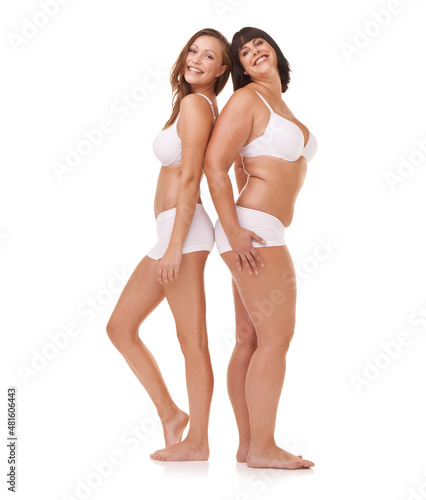 Just happy being themselves. Two women of different body shapes standing together back to back while isolated on white.