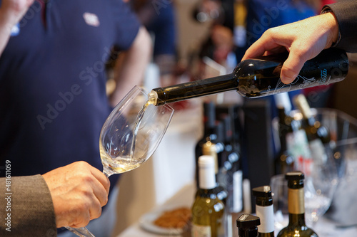 Pouring white wine into a wine during a party,close-up. High quality photo