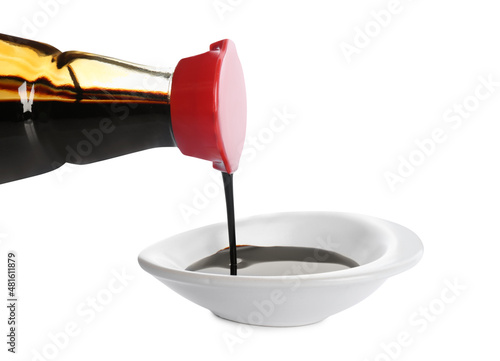 Billede på lærred Pouring soy sauce into bowl against white background