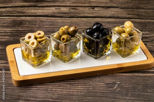 Olive oil with mixed vegetables on wooden background