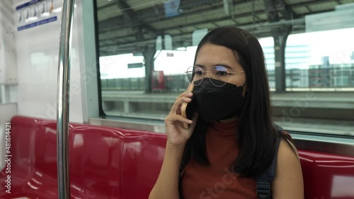 Women wearing face mask and using mobile tphone on subway train,Safety on public transport,New normal during covid-19 pandemic photo