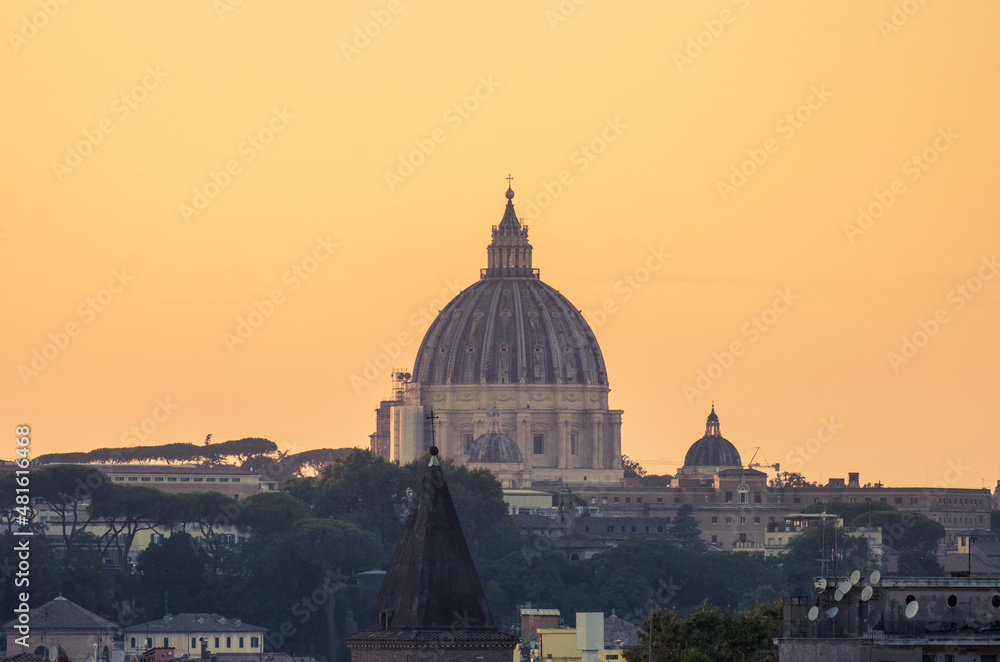 Saint Peter's Basilica dome seen from the Orange Trees Garden (Giardino degli Aranci) at sunset with an orange clear sky