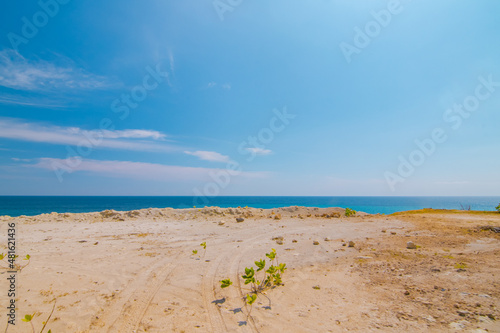 White sand beach and gentle waves with stunning green hills on the South side of Lombok Island  Indonesia