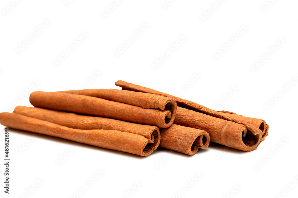 Heap of fragrant cinnamon sticks on white background