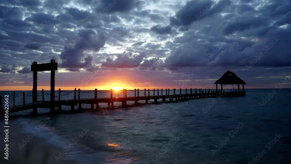Timelapse of a sunset on a beach on the island of Cozumel in Mexico with the silhouette of the wooden pier in the background Timelapse of a sunset on a beach on the island of Cozumel in Mexico with the silhouette of the wooden pier in the background