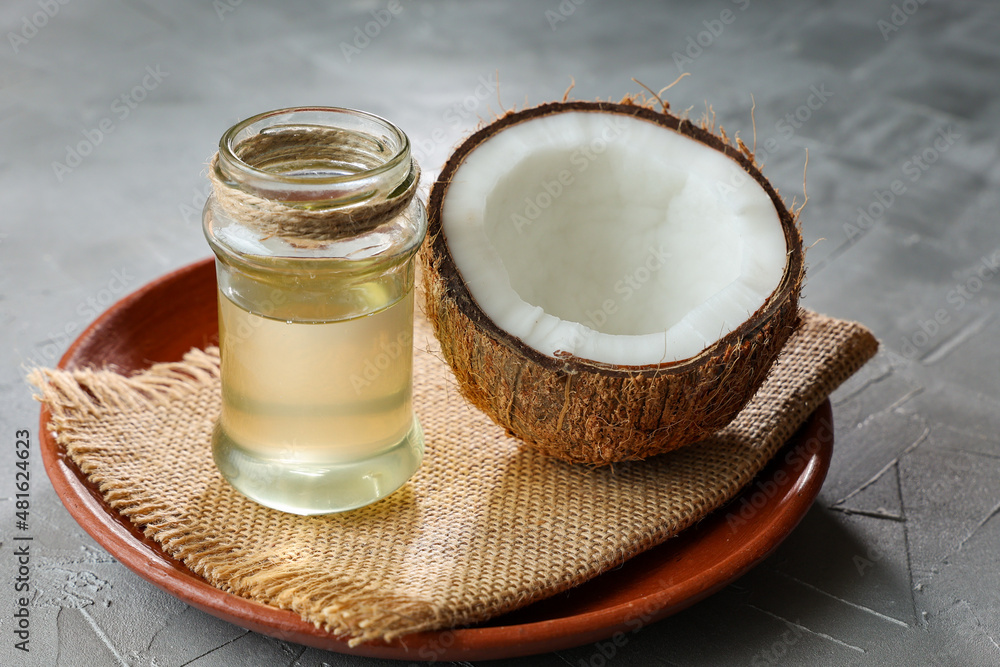 Coconut Oil in glass jar with Coconut cut open in half. pure homemade