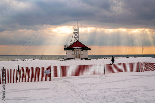 Dramatic clouds over an offleash dog park and lifeguard station  on the shore of  Lake Ontario in winter..  Suitable for background, space for text. photo