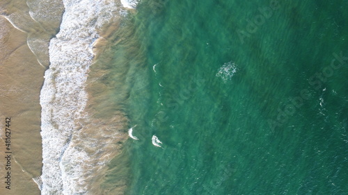 Aerial view of an emerald green sea and big foaming waves. Indian Ocean. Dikwella beach. Sri Lanka