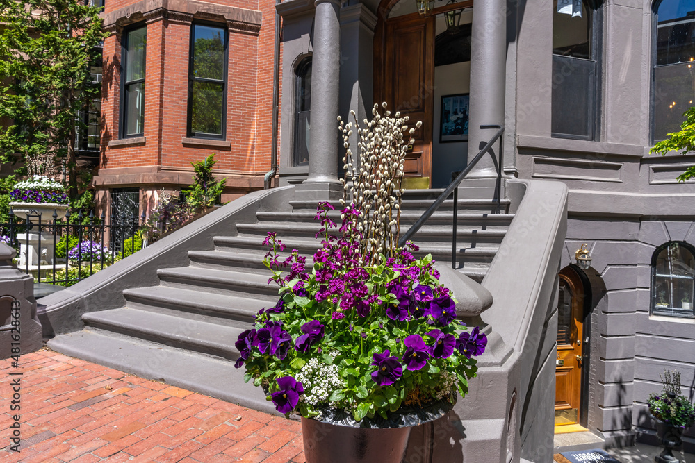 Decoration of the entrance to the house for Easter. Pot of flowers near an old house in Boston with willow branches.
