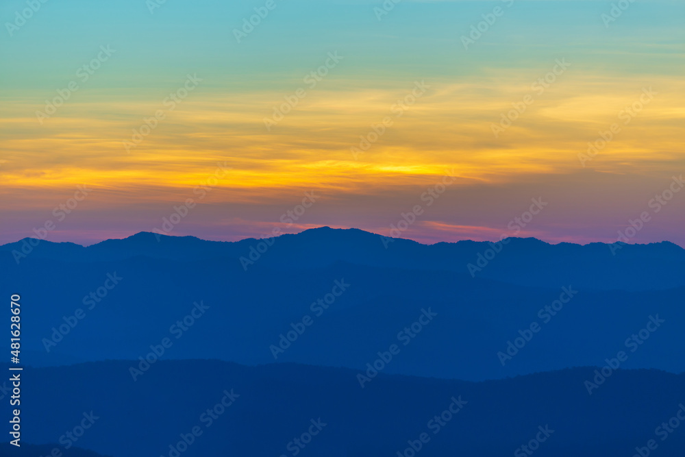 Sunrise or sunset evening time over the mountains and forest  with red or orange clouds sky.