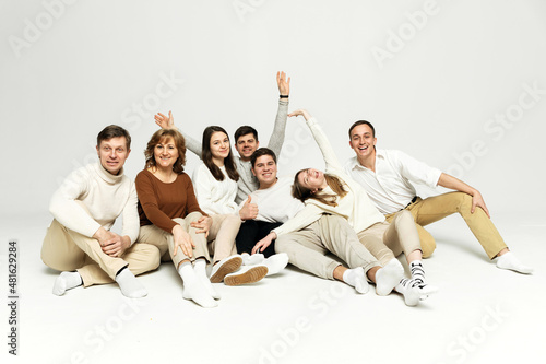 young family with seven people are having fun on a white background. happy people. a group of people of different nationalities and ages are hugging.